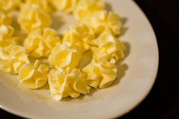 bowl of butter portions on a white oval plate-closeup