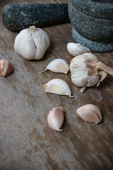Fresh Garlic bulb, the raw garlic on the wooden background. Around the world, people used garlics in every cuisine. It can used as an effective form of plant-based medicine in many ways.