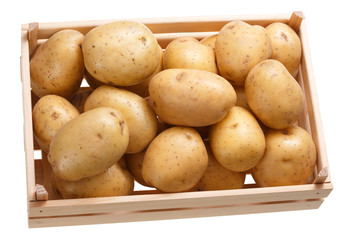 Potato tubers in a wooden box. Isolated on white background.