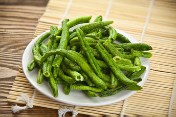 green beans pods on awhite plate on table