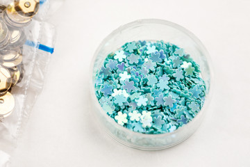 Different colour beads for handcraft and beading in plastic packages on a white background