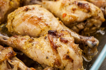 Juicy baked chicken legs with spices closeup shot