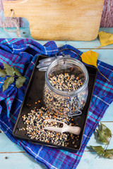 Lentils mix in the jar and tray. Blue wooden table and background.