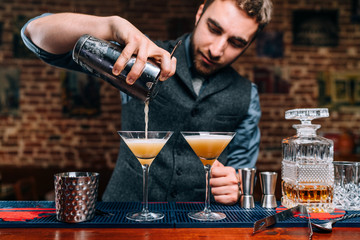 Close up details of barman pouring fancy alcoholic drinks at party