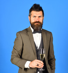 Businessman with confident face holds sparkling wine.