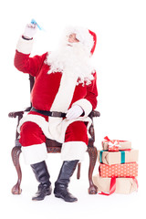Portrait of Santa Claus sitting in chair and launching paper airplane