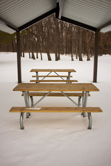 Plakat Vacant wooden table and benches in snow