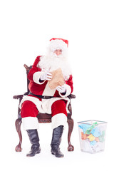 Bad Santa Claus reading letters from kids, crumpling them and throwing into trash basket