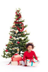 Fototapeta na wymiar Portrait of cute mixed race little boy sitting on floor near Christmas tree with gift box in his hands