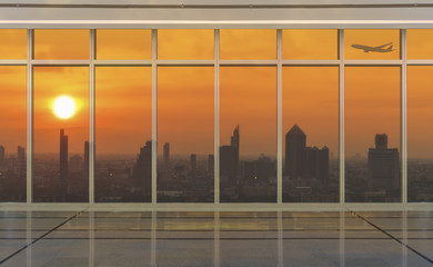 Glass wall in modern office building at sunset with airplane