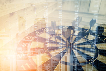 Red dart arrow hitting in the target center of dartboard business success ideas concept on wooden floor double exposure with financial chart stock
