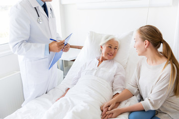 Fototapeta premium senior woman and doctor with clipboard at hospital