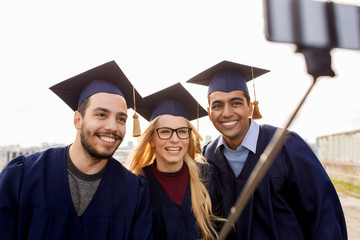 Fototapeta premium happy students or graduates taking selfie outdoors