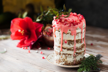 Festive honey cake with pomegranate seeds on wooden background