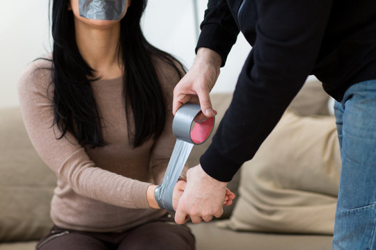 criminal tying woman with adhesive tape