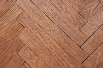 Part of the parquet in a natural wood texture laid out on the floor like a herringbone
