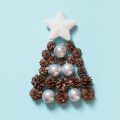 Christmas tree by cones, silver balls and white star. Top view.