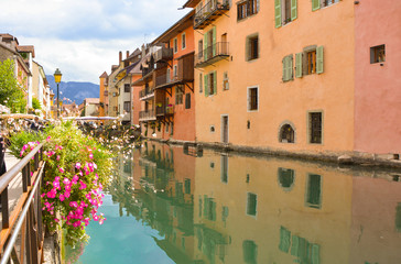 Fototapeta na wymiar The city of Annecy. Historical medieval houses and a canal, embankment with flowers and bridges in the resort town of Annecy in France in the summer.