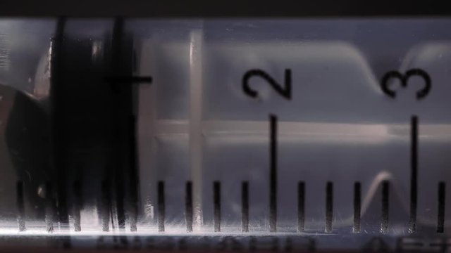 Filling us a syringe with fluid and air bubbles.