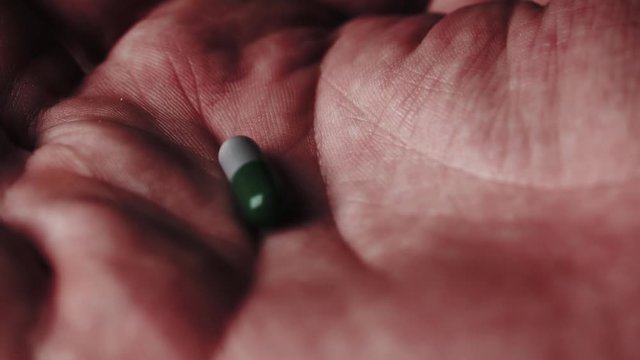 Pill falling in an open palm. Multiple takes.