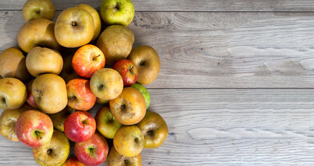 red and yellow organic apples on wooden table