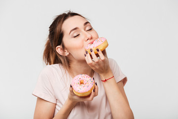 Close up portrait of a satisfied pretty girl eating donuts - Powered by Adobe