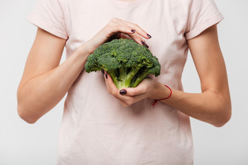 Close up of a woman holding broccoli