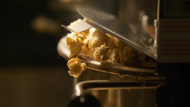 Fresh roasted pop corn pop out of the bowl - pop corn maker in a movie theater