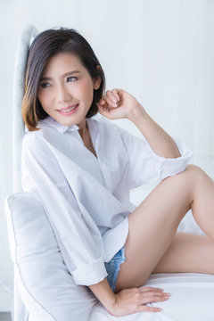 beautiful asian girl white white shirt ralax on white bed next to window curtian with sunlight beauty skin concept