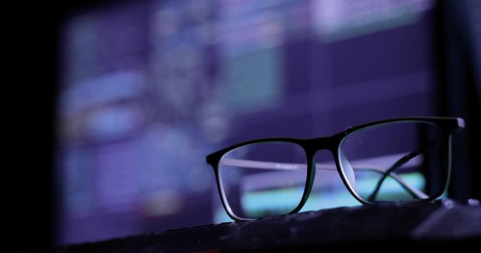 Cyber attack concept. glasses on the keyboard, on the background of the monitor