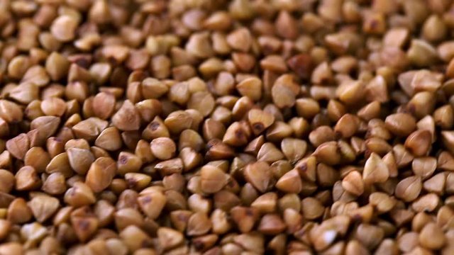 Rotating raw buckwheat. Spinning closeup dry uncooked seeds