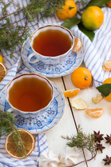A beautiful still life with cups of tea and tangerines. Christmas tea-party.