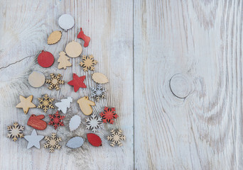christmas tree made of christmas decorations on light wooden background