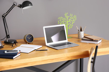 Comfortable workplace with laptop on table in office