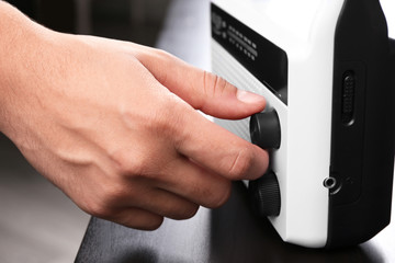 Person tuning white radio, closeup