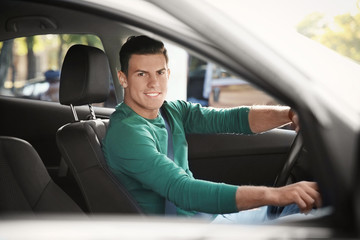 Fototapeta na wymiar Young man on driver seat of car