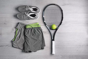  Tennis racket, ball, clothes and shoes on wooden background © Africa Studio