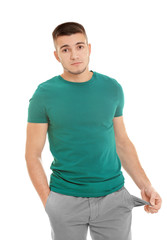Obraz premium Young man showing his empty pocket on white background
