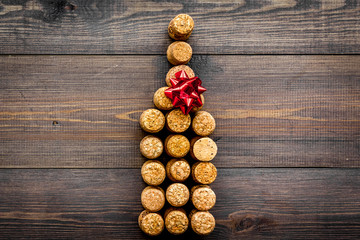 Corks of wine bottles in shape of bottle on dark wooden background top view copyspace