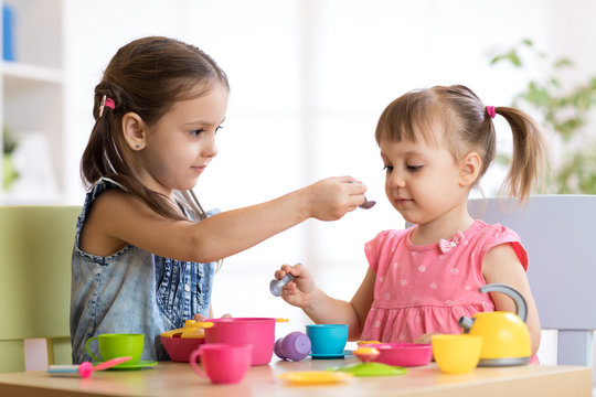 Kids playing with plastic tableware