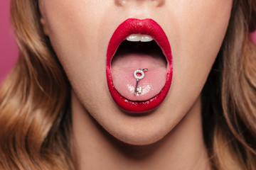 Cropped shot of lady with red lips holding key in mouth