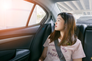Beautiful asian woman looking through car window