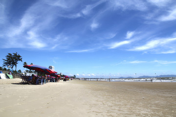 Wide beach with umbrellas against the backdrop of the beautiful blue sky