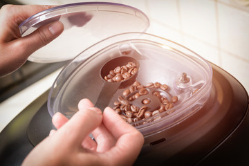 Adding coffee beans to the grinder