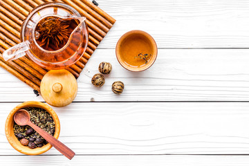 Tea break. Tea pot, cups and tea leaves on white wooden background top view copyspace