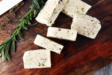Butter with thyme and rosemary and lemon zest. Sliced on a wooden board with herbs