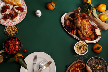 Traditional dinner with roasted chicken, pate and tomato bruschettas on dark green background....