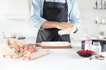 A cook with eggs on a rustic kitchen against the background of men's hands