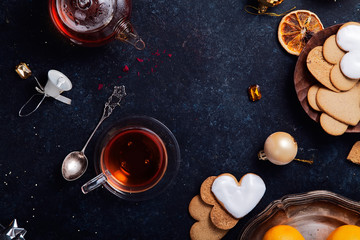 Teatime with heart-shaped ginger cookies and tangerines. Christmas background with festive decoration. Horizontal composition