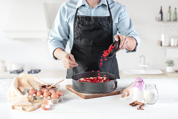 A cook with eggs on a rustic kitchen against the background of men's hands